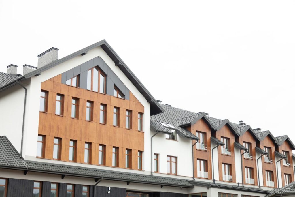 modern multi family building with wood and gray siding, sleek dark gray roof.